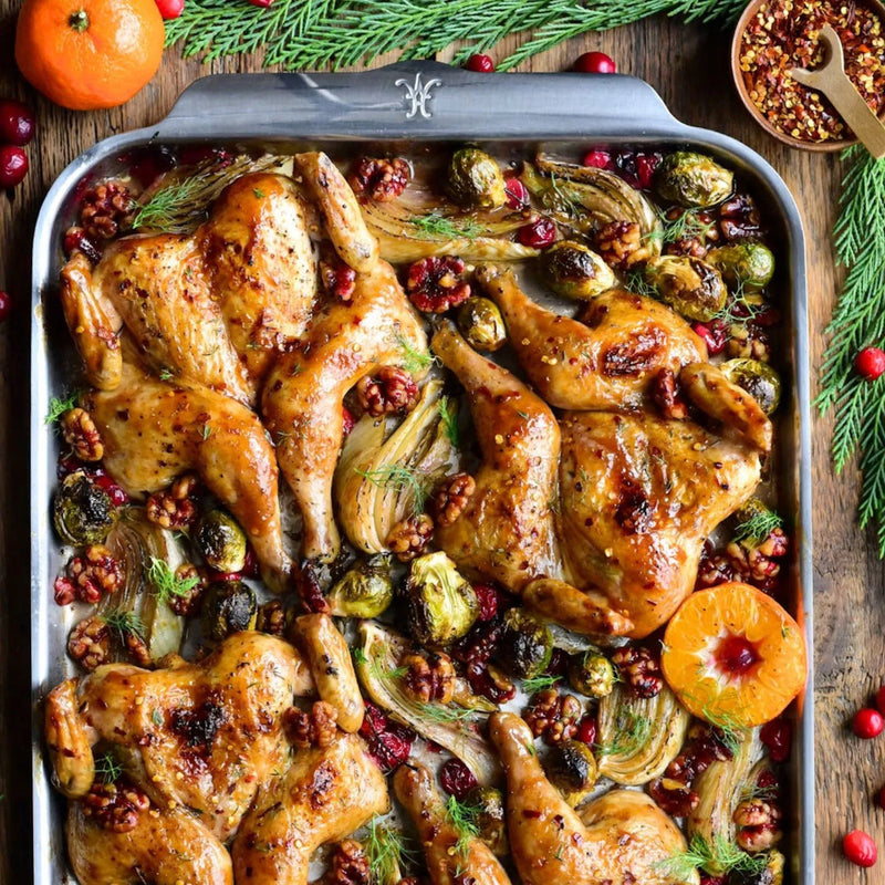 Hestan | OvenBond Tri-Ply Bakeware, Single Half Sheet Pan showcasing a beautifully roasted spatchcocked chicken with Brussels sprouts, fennel, walnuts, and cranberries, demonstrating exceptional heat distribution.
