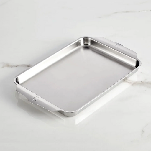 Hestan Provisions | OvenBond Tri-Ply Bakeware, Medium Sheet Pan with curved handles on a smooth surface, showcasing its durable stainless-steel construction ideal for even heat distribution.