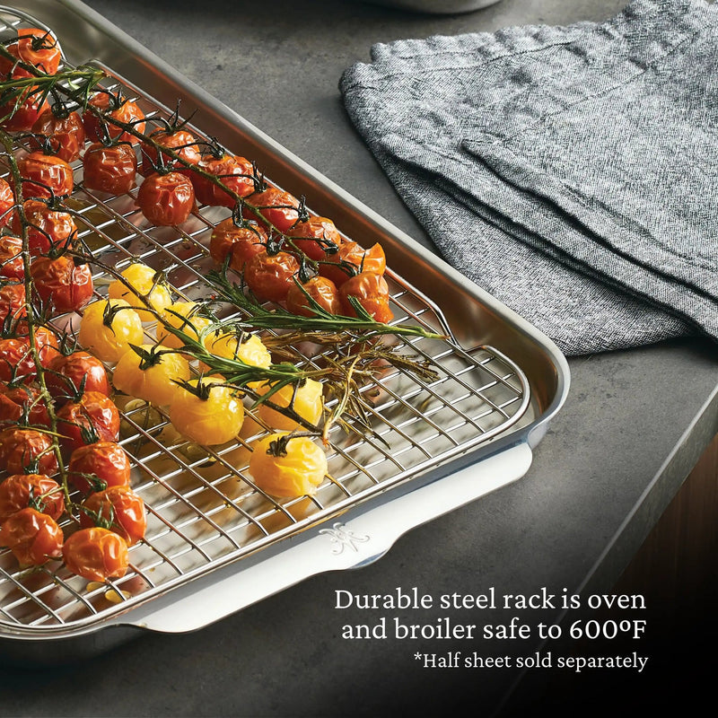 Hestan Provisions OvenBond rack on half-sheet pan with tomatoes and rosemary; durable, oven-safe to 600°F. Grey kitchen towel aside. Half sheet sold separately.