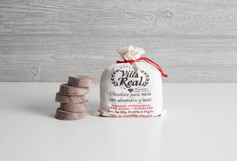 Villa Real Mexican Hot Chocolate: Vanilla / Small - 5 Discs displayed with draw-string pouch, highlighting its artisan-made, Oaxaqueño origins with almond and walnut.