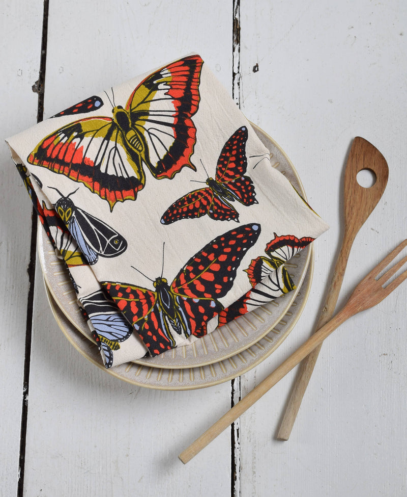 Hearth and Harrow - Butterfly Tea Towel displayed on ceramic plates with wooden utensils; features organic cotton, hand-printed with eco-friendly inks, 30x30.