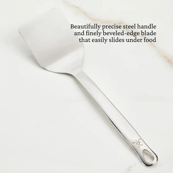 Hestan Stainless Steel Spatula/Turner displayed on a marble surface, showcasing its sleek design and functionality as a premium kitchen utensil from Athens Cooks.