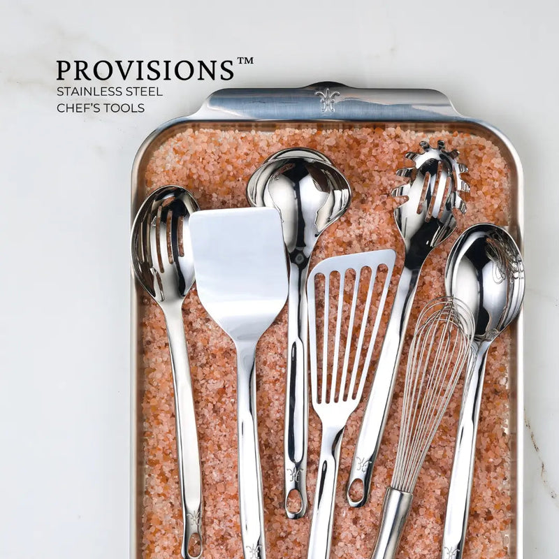 Hestan Provisions | Stainless Steel Pasta Fork, 13 on pink salt tray, showcases precision-crafted, ergonomic design with artisan-polished finish and embossed monogram, ideal for discerning cooks.