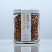 The Chai Box | Lavender Nights - Caffeine Free Rooibos Lavender Tea - 6.0oz pouch, featuring jars of dried herbs and a close-up of the packaging.