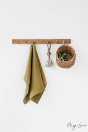 Linen tea towel hanging on a hook with a basket. Made from European linen, perfect for kitchen tasks. Part of Athens Cooks' curated kitchen collection.
