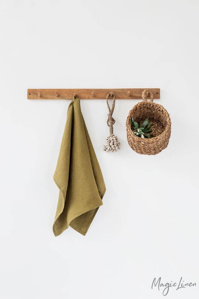 Linen tea towel hanging on a hook with a basket. Made from European linen, perfect for kitchen tasks. Part of Athens Cooks' curated kitchen collection.