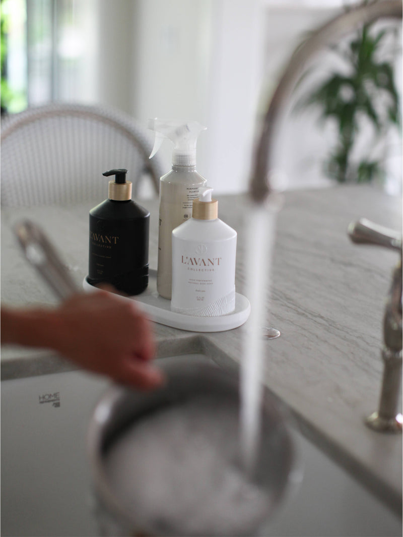 L'AVANT Collective - Fresh Linen High Performing Dish Soap in a matte white glass bottle, placed on a kitchen counter, ideal for stylish, eco-friendly dishwashing.