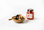 Matiz - Matiz Paella Sofrito - 12.3oz Jar beside a seafood stew in a ceramic bowl, showcasing its use as a flavorful cooking base.