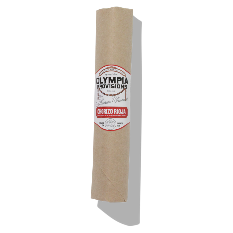 Olympia Provisions - Chorizo Rioja, a Spanish-style cured salami wrapped in paper, showcasing its natural hog casing and award-winning flavor profile.