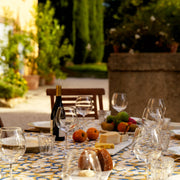 Couleur Nature - Forest Harvest tablecloth showcases a Mediterranean-style garden setting with wine, cheese, and fruit, highlighting its artisanal, hand-printed design.