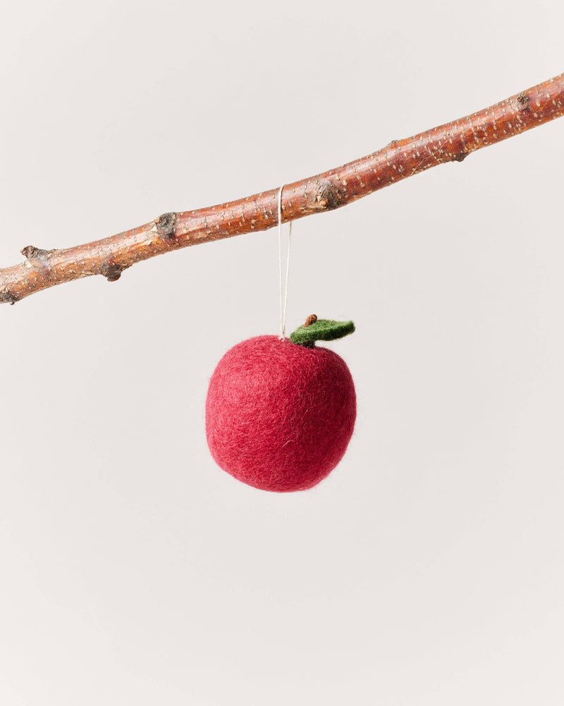 Farmhouse Pottery - Felted Fruit Ornament: Pear hanging on a twig, featuring a handcrafted red felt apple with a green leaf and brown stem detail.