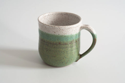 RachaelPots - 12 Oz Original Mug: Sage, crafted from speckled stoneware, features a green and off-white glaze with a thumb rest on the handle.