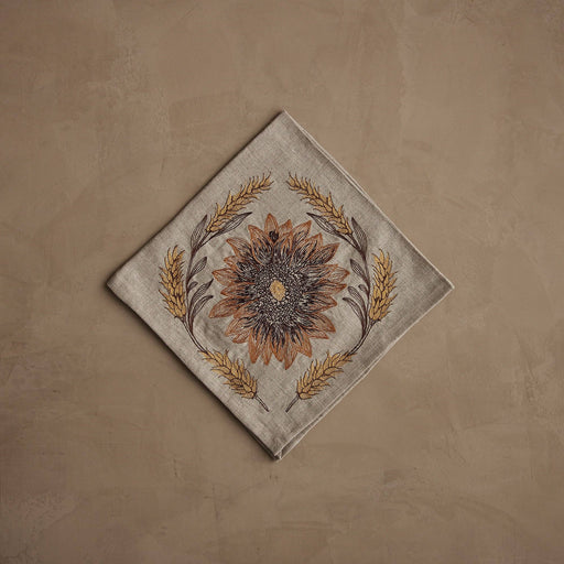 Coral & Tusk - Sunflower and Wheat Dinner Napkin: Neutral-tone linen with embroidered sunflower and wheat wreath, perfect for autumn harvest table settings. Measures 20 × 20.