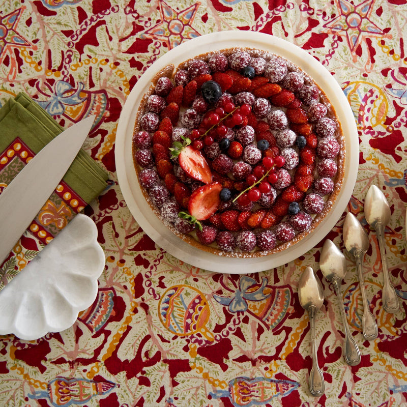 Mixed-berry tart on Couleur Nature - Noel Red & Green French Tablecloth, showcasing holiday-themed design, surrounded by vintage dessert spoons and green napkins, creating a festive dining ambiance.