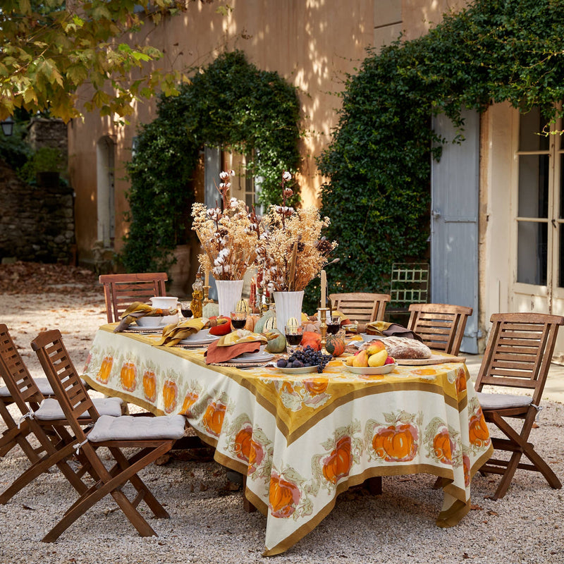Caravan Home - Pumpkin Orange & Mustard Tablecloth on a rustic autumn-themed outdoor dining setup with pumpkins, vases, and cozy place settings.