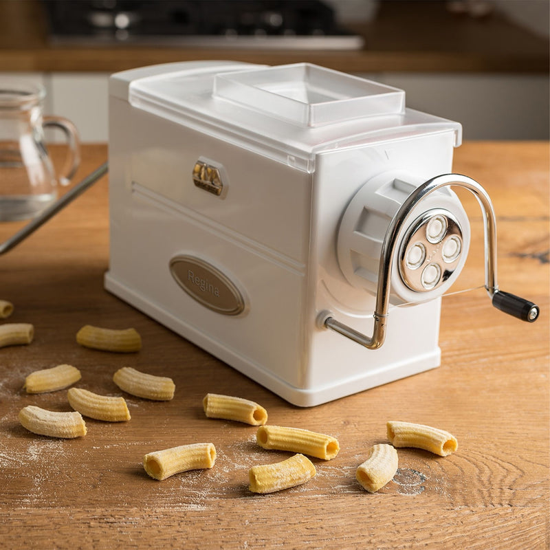 Marcato | Pasta Regina manual pasta machine on a table, showcasing its compact design with a silver handle, ideal for making various pasta types at home.