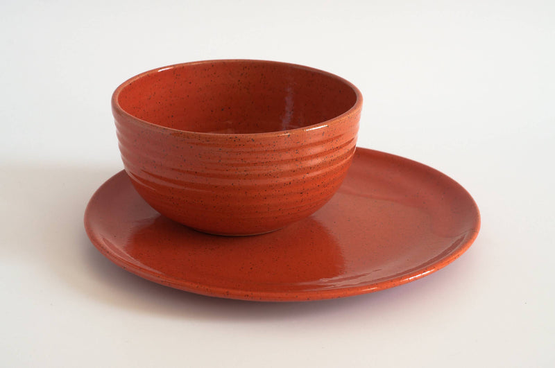 RachaelPots - Laura Bowl: White. A tall, speckled ceramic bowl with ribbed grip, sitting on a matching plate, designed for versatile bowl meals.