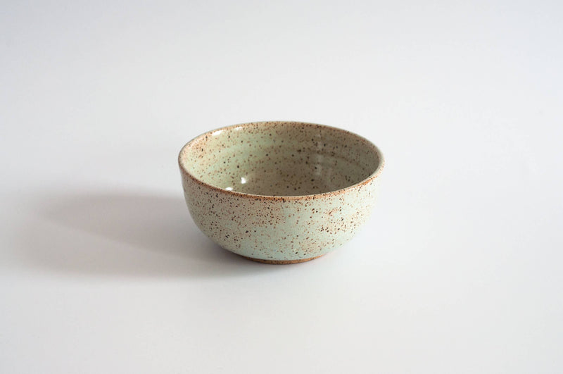 RachaelPots - Breakfast Bowl: Sage, a minty-green ceramic bowl with brown flecks and rim, ideal for versatile kitchen use. Hand-thrown in Brooklyn, microwave and dishwasher safe.