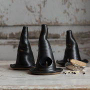 Gravesco Pottery - Witch Hat Incense Burner: Three black ceramic witch-hat incense holders, handcrafted with hollow design for burning incense, displayed with matches and a glass vial on wood.