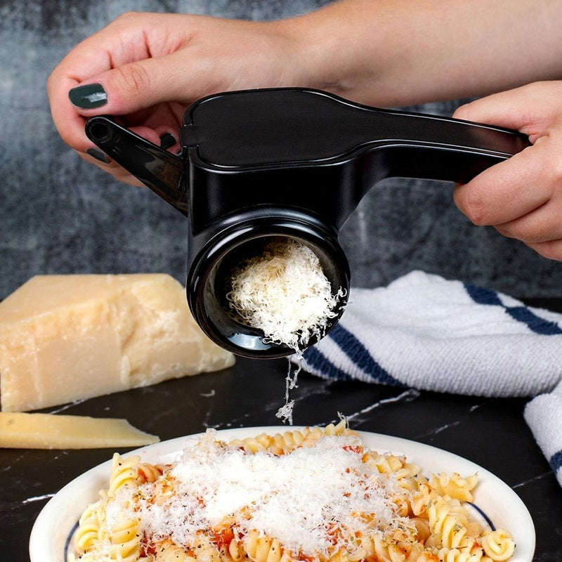 Person using a Microplane Rotary Grater to grate cheese over a plate of pasta.