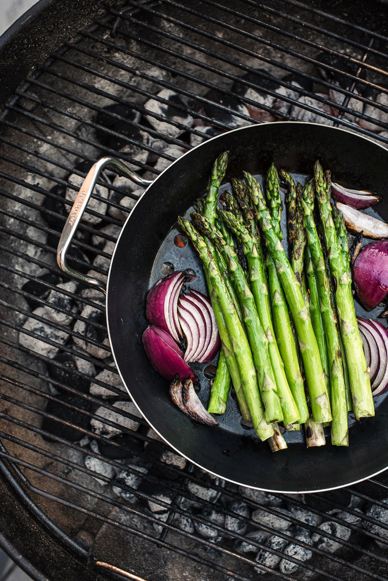 de Buyer | Outdoor Fry Pan - Long Handle, designed for BBQ enthusiasts, features blue carbon steel and a perforated design for grilling delicate foods without losing them through grates.