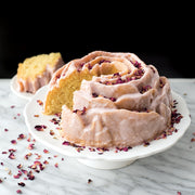 Nordic Ware | Rose Bundt® Pan: A cake on a white plate, showcasing a rose shape with petal detailing, ideal for creating beautiful floral-themed desserts.