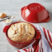 Emile Henry Bread Pot with crusty loaf and butter, showcasing a handcrafted French ceramic baker for perfect homemade bread, ideal for culinary artistry from Athens Cooks.