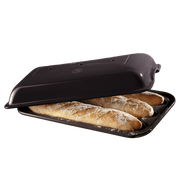 Emile Henry Baguette Baker in charcoal — open baker with three freshly baked baguettes