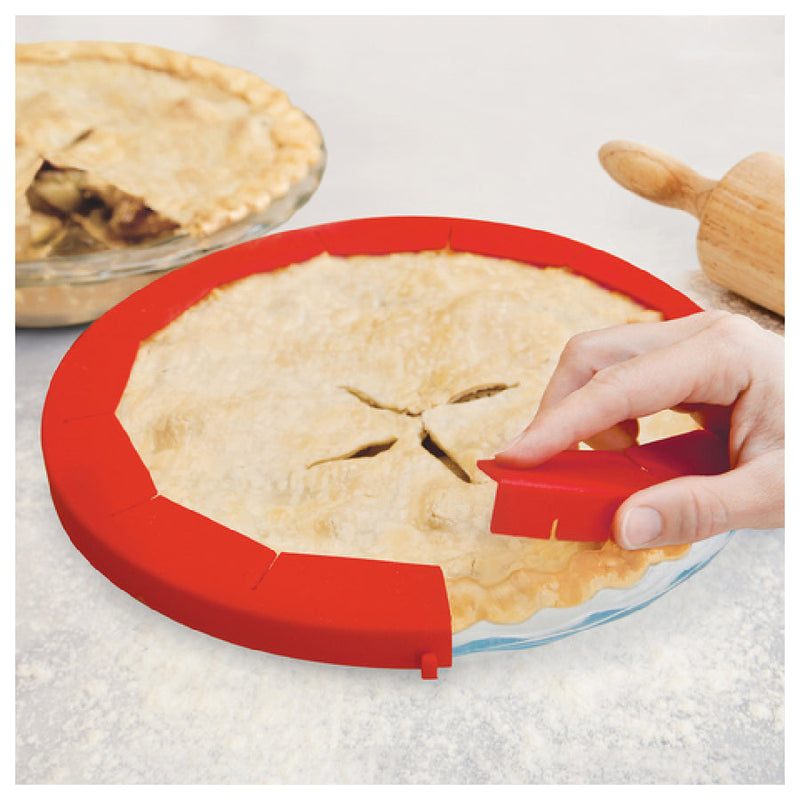 Hand holding an Adjustable Pie Crust Shield, a baking tool from Athens Cooks, designed to protect pie crusts from burning during baking.