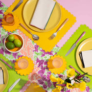 ATELIER SAUCIER - Macaw Burlap Napkins | Set of 4 displayed on a table with cutlery, featuring vibrant colors and a tropical theme, perfect for enhancing dining experiences.