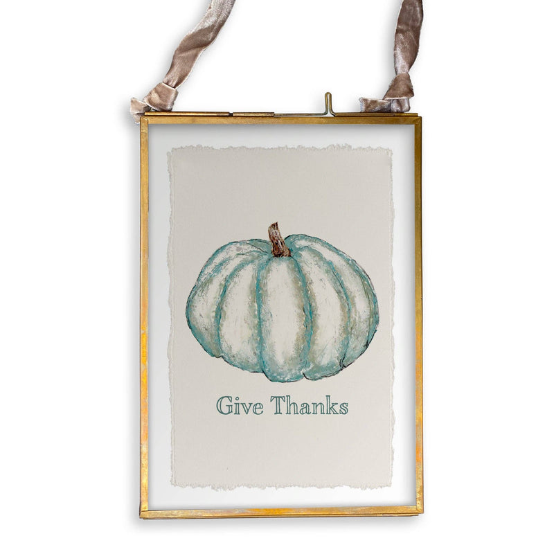 Framed art print with teal pumpkin illustration and Give Thanks text, hung by velvet ribbon. Part of French Graffiti - Blue Pumpkin collection at Athens Cooks.