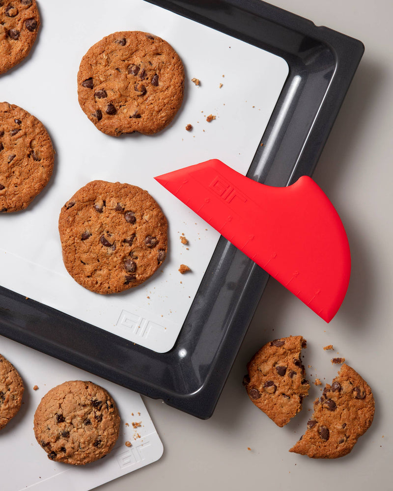 GIR Get It Right - GIR Scraper: Slate next to a tray of cookies, showcasing its versatility for baking and kitchen tasks.