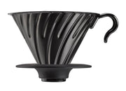 HARIO USA - V60 Metal Dripper: Silver, a stainless steel pour-over coffee dripper with spiral ridges for precision brewing, shown atop a silicone holder with a measuring spoon.