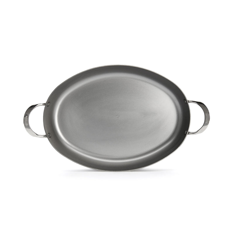 de Buyer | Oval Roasting Pan: A silver oval pan with two handles, ideal for roasting meats or vegetables, enhancing your cooking and dining experience.