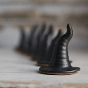 Gravesco Pottery - Black Witch Hat: Matte-black ceramic witch hat-shaped ring holder on a cookie base, perfect for Halloween decor or ring display.
