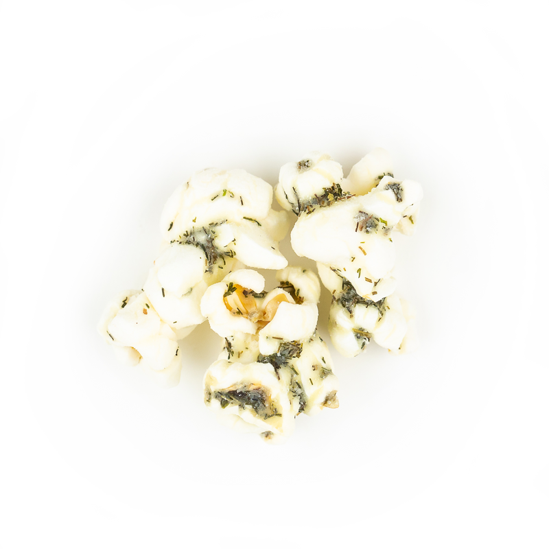 Poppy Hand-Crafted Popcorn - Dill Pickle Popcorn, featuring a pile of crunchy popcorn seasoned with white cheddar, vinegar, and dill, offering a tangy, savory snack experience.