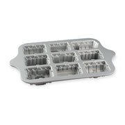 Nordic Ware | Train Cake Pan featuring nine train-shaped molds on a silver tray with holes, perfect for creative baking with children.