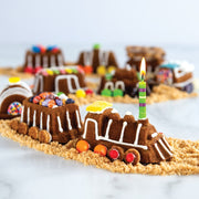 Nordic Ware Train Cake Pan: A whimsical cake shaped like a train with a lit candle, perfect for creative baking projects with kids.