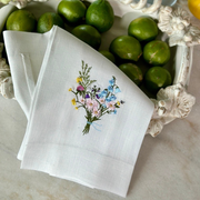 Arte Italica & Crown Linen Designs - Wildflower Bouquet Linen Towel: White (Multi), featuring embroidered wildflowers, displayed with limes on a white surface. Perfect for adding elegance to kitchen decor.