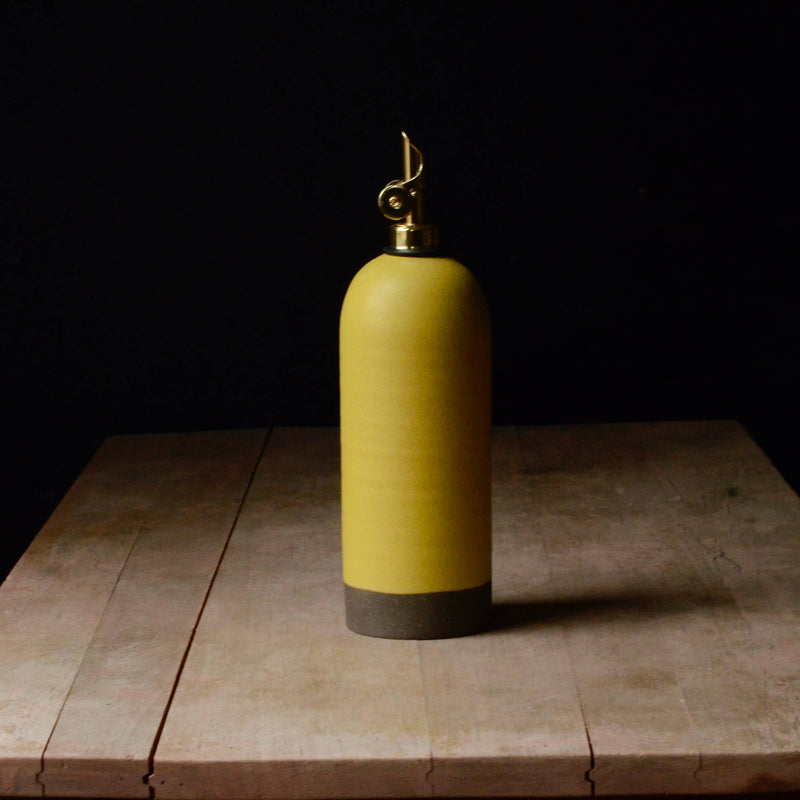Rose Line Pottery - Oil Bottle - Yellow - 22 Ounces, handcrafted stoneware with a brass nozzle, ideal for olive oil or syrup, on a rustic wooden table.