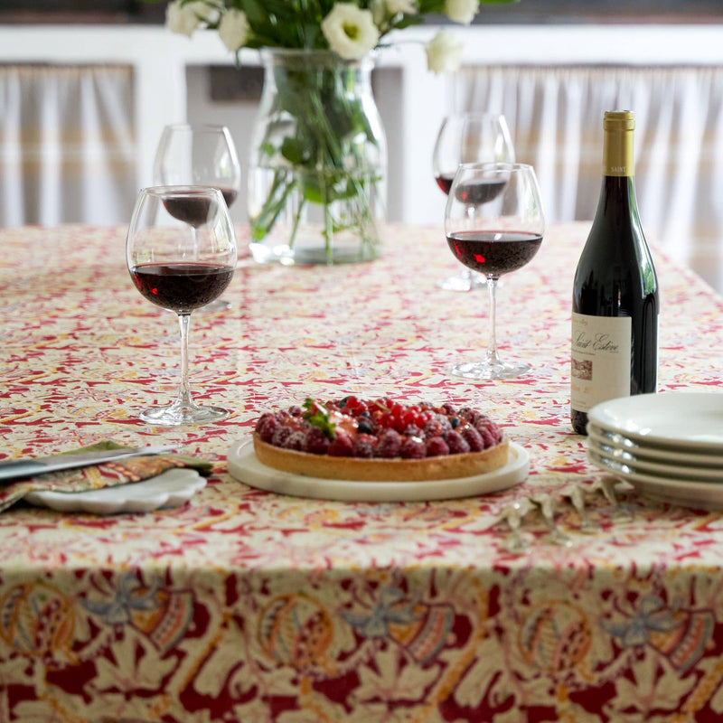 Couleur Nature - Noel Red & Green tablecloth enhances a festive table with a berry tart, wine, and flowers, embodying casual elegance and tradition.