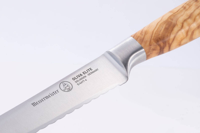 Messermeister Oliva Elite Reverse Scalloped Utility Knife with olive wood handle and serrated blade, perfect for slicing textured and smooth foods effortlessly.