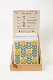 Three Bluebirds Swedish Dishcloths - Pink Wildflowers, featuring a biodegradable cloth with floral designs, presented in a wooden display box.