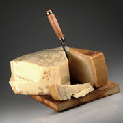 Nicola's Marketplace - Parmigiano Reggiano DOP Mitica® 36 months: 7 Ounces, a hard, aged cheese wedge with visible granular texture on a wooden board, knife included.