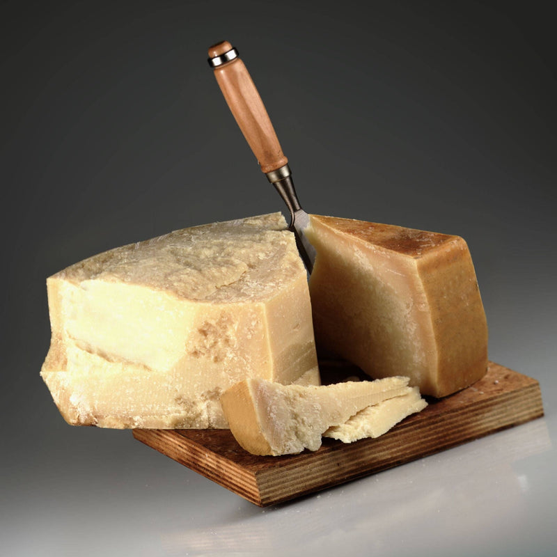 Nicola's Marketplace - Parmigiano Reggiano DOP Mitica® 36 months: 7 Ounces, a hard, aged cheese wedge with visible granular texture on a wooden board, knife included.