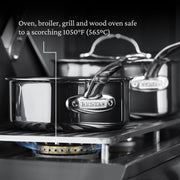 Hestan | Cookware, 1.5qt Saucepan + Lid on gas burner, showcasing high heat tolerance up to 1050°F with durable, molecular titanium stainless-steel construction.