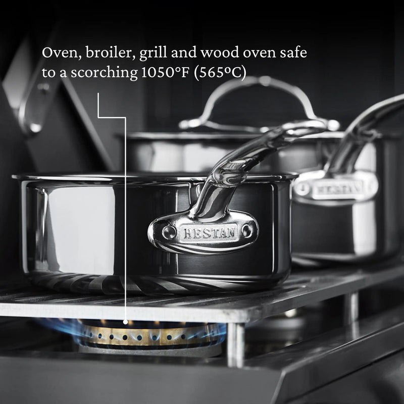 Hestan | Cookware, 1.5qt Saucepan + Lid on gas burner, showcasing high heat tolerance up to 1050°F with durable, molecular titanium stainless-steel construction.