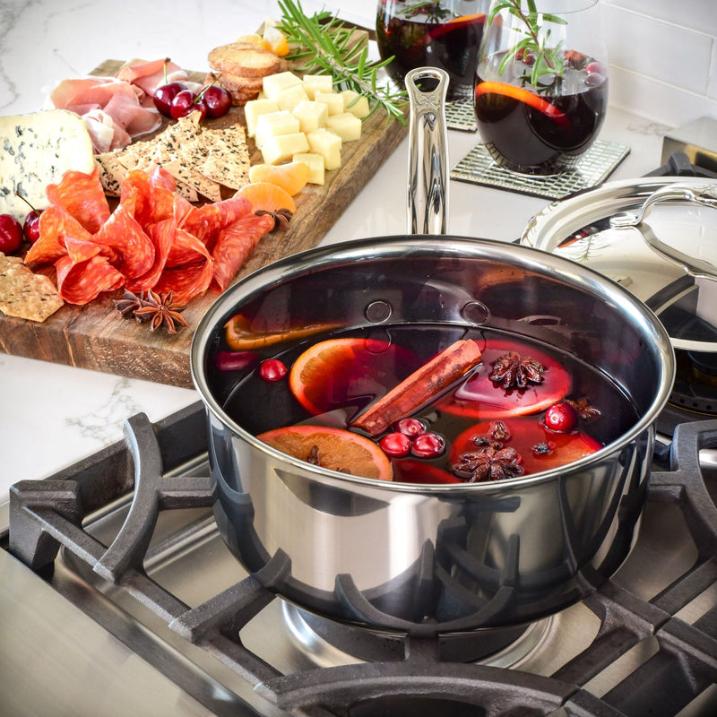 Hestan NanoBond 2qt Saucepan with mulled wine ingredients simmering, showcasing its wide base and ergonomic handle amidst a charcuterie board.