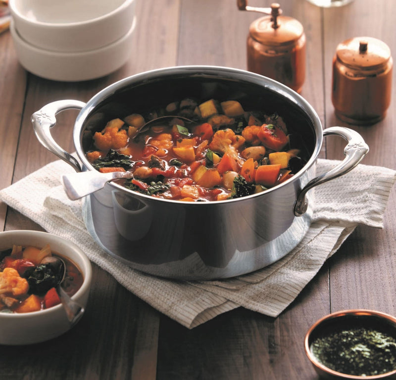 Hestan | NanoBond Cookware, 3qt Soup Pot filled with vegetable stew, featuring ergonomic handles and a ladle, showcasing durable, innovative titanium-bonded stainless steel technology.