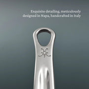 Close-up of a polished stainless-steel wine-bottle opener, branded with a decorative emblem, reflecting exquisite detailing and craftsmanship from Napa and Italy.